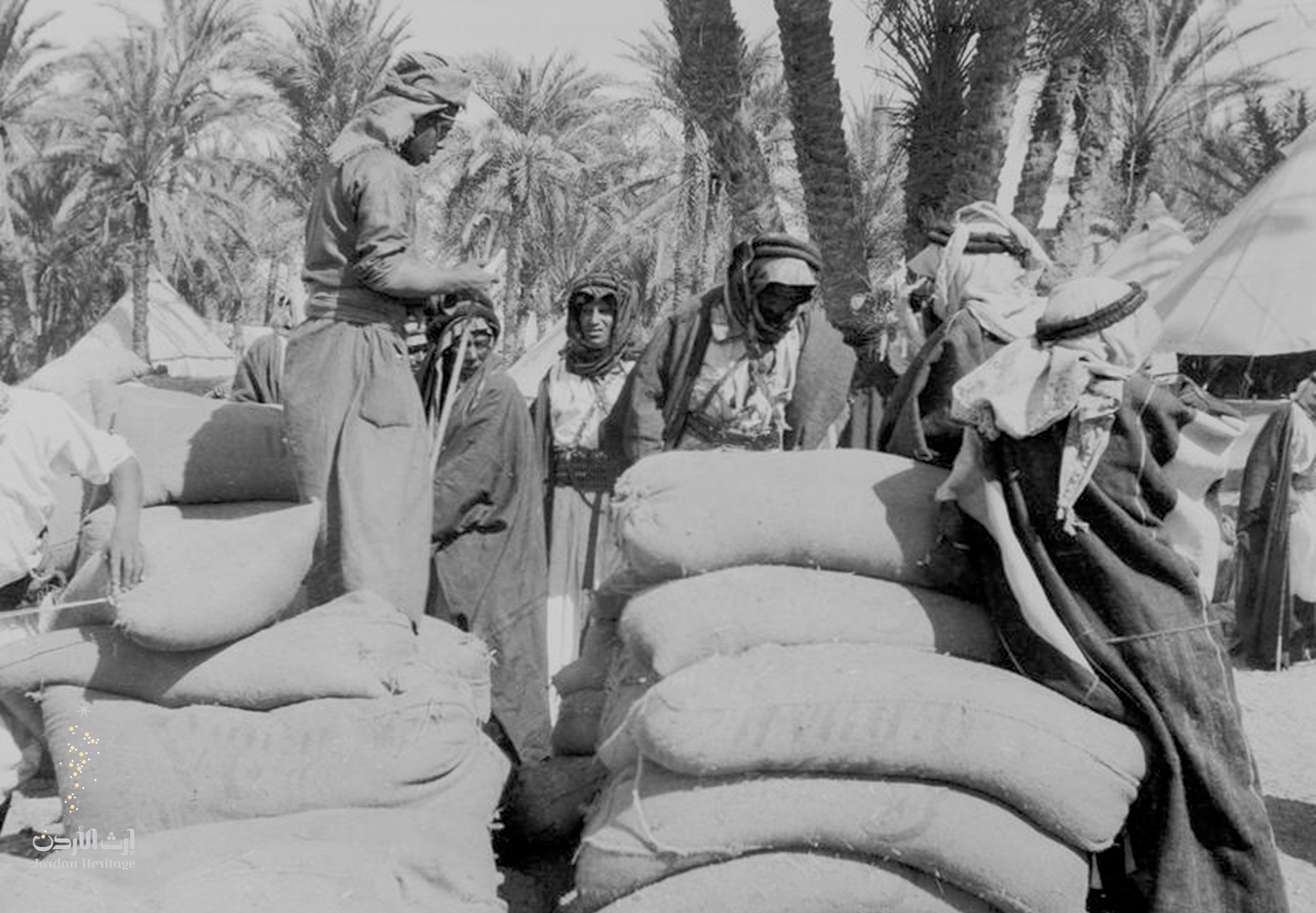 مجموعة من رجال قبيلة بني عطية يقومون بتحميل المؤن لقوات الثورة في العقبة استعدادا لنقلها لمعسكر القويرة